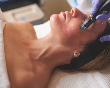 A woman enjoying a facial treatment at a spa, with soothing products applied to her face for relaxation and rejuvenation.