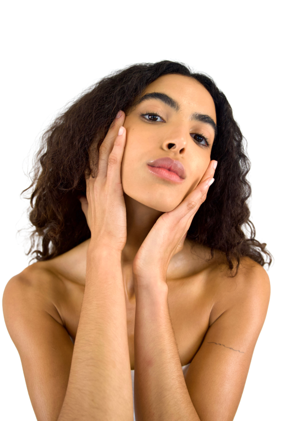Woman with curly hair posing, resting hands on cheeks, showcasing natural beauty.