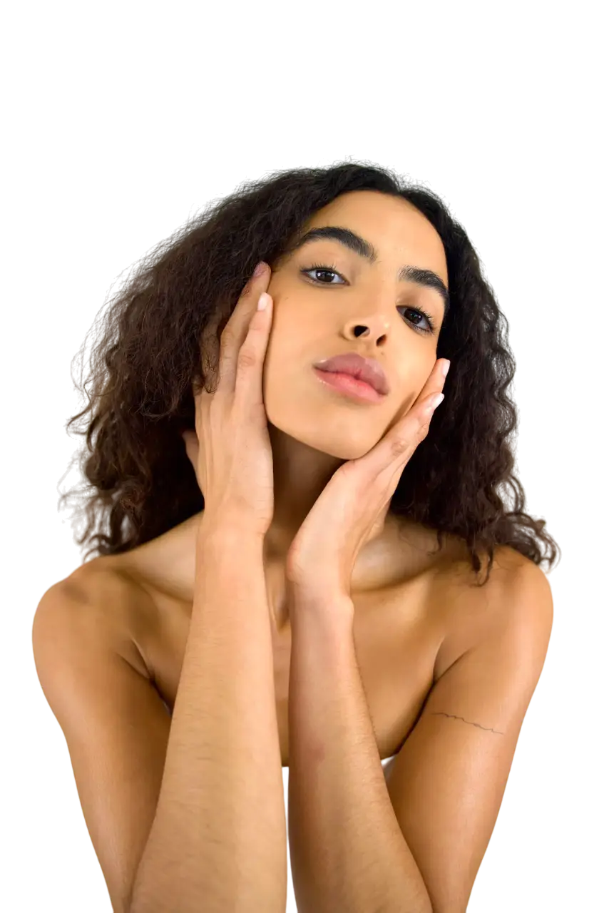 Woman with curly hair and flawless skin posing against a neutral background.