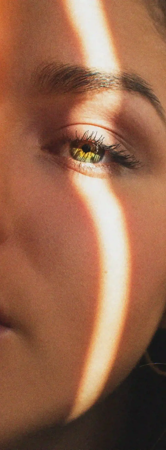 A woman with brown eyes and a yellow eye, showcasing a unique and intriguing contrast in her gaze.